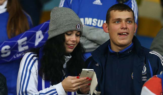 Boyfriend and girlfriend in football t-shirts watching a game